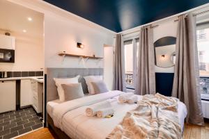 a bedroom with a large bed with towels on it at Cute Studio in the 16th near the Arc de Triomphe in Paris