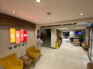 a hotel lobby with chairs and a hotel sign on the wall at Bolu Evim Otel in Bolu