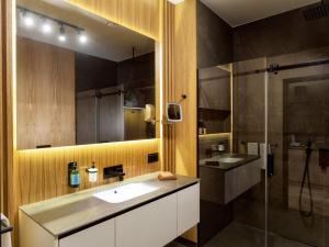 a bathroom with a sink and a shower at City Park Hotel & Residence in Poznań