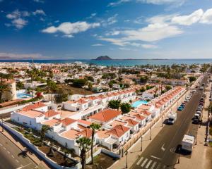 een luchtzicht op een stad met gebouwen en de oceaan bij Las Casitas de Corralejo in Corralejo