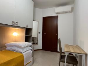 1 dormitorio con 1 cama y 1 mesa con silla en Appartamento Tufo - 10min dalla Rocchetta Mattei, en Vergato