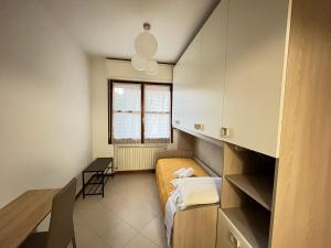 Habitación pequeña con cama y escritorio. en Appartamento Tufo - 10min dalla Rocchetta Mattei, en Vergato