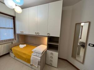 1 dormitorio con cama, armarios blancos y espejo en Appartamento Tufo - 10min dalla Rocchetta Mattei, en Vergato