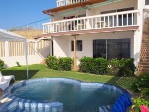a swimming pool in the yard of a house at Los Sonidos de las Olas in Santa Marianita