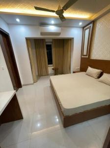 a bedroom with a bed and a ceiling fan at Minato Homz in Gurgaon