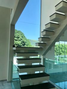 una escalera en un edificio con ventana en Casa de vidro com vista para a Mata Atlântica no Centro de Miguel Pereira, en Miguel Pereira