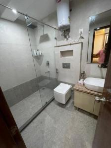 a bathroom with a shower and a toilet and a sink at Minato Homz in Gurgaon