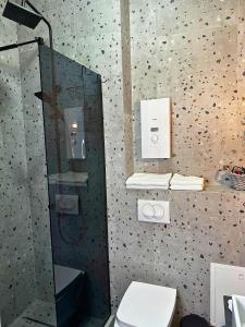 La salle de bains est pourvue d'une douche en verre et de toilettes. dans l'établissement Sara Apartment, à Strumica