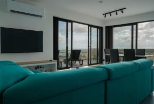 a blue couch in a living room with a television at Lux Sea&Country Views with Pool in Mellieħa