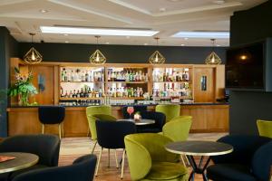 a bar with green chairs and tables in a restaurant at Hotel Puerto Palace in Puerto de la Cruz