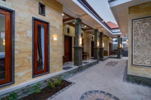 an empty walkway in a building with columns at Pratiwi House Lembongan in Nusa Lembongan