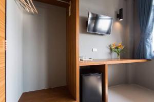 a room with a desk and a tv on the wall at Leisure Hostel in Krabi town