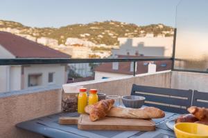 a table with croissants and bread on a balcony at Lecerf Central in Cannes