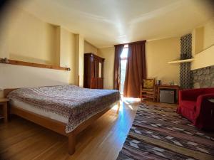 a bedroom with a bed and a red couch at Hotel Mirhav in Goris