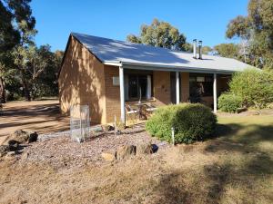 a small brick house with a gambrel roof at Pomonal Cottages Grampians in Halls Gap