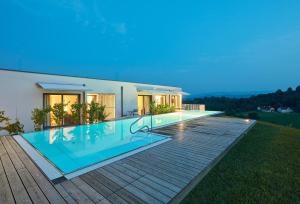 a house with a swimming pool on a deck at RELAX APARTMENTS Hochgraßnitzberg in Spielfeld