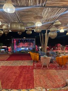a room with a stage with chairs and a rug at AGAFAY BIV FOLK & SPA by WE CAMPS in Ourika