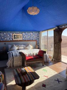 een slaapkamer met een bed en een blauw plafond bij AGAFAY BIV FOLK & SPA by WE CAMPS in Ourika