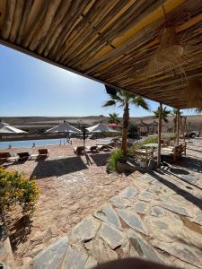 a sandy beach with umbrellas and chairs and the ocean at AGAFAY BIV FOLK & SPA by WE CAMPS in Ourika