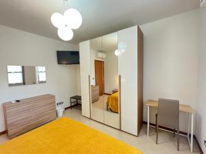 1 dormitorio con espejo, cama y mesa en Appartamento Tufo - 10min dalla Rocchetta Mattei, en Vergato