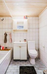 a bathroom with a toilet and a sink and a tub at Villa Kakelbont! in Föllinge