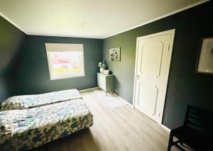 una camera da letto con pareti verdi, un letto e una finestra di Villa Kakelbont! a Föllinge