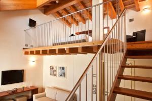uma escadaria numa sala de estar com paredes brancas e tectos em madeira em Al Tezzon Hotel em Camposampiero