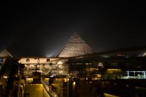 una vista de las pirámides de Egipto por la noche en Sun and Sand Guest House, en El Cairo