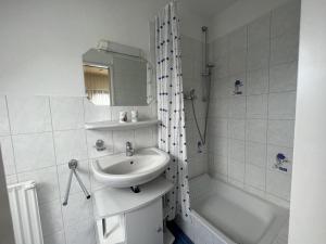 a bathroom with a sink and a bath tub at STOE 14a Gästehaus Iden, App 3 in Niendorf