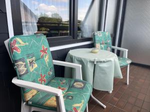 a table and two chairs sitting on a balcony at STOE 14a Gästehaus Iden, App 3 in Niendorf