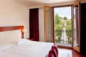ein Schlafzimmer mit einem Bett und einem großen Fenster in der Unterkunft Al Tezzon Hotel in Camposampiero