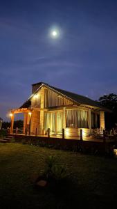 a wooden house with a moon above it at night at Mirador da Montanha in Praia Grande