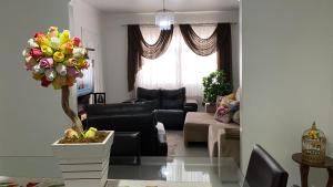 een woonkamer met een bank en een tafel met een plant bij Casa Bombinhas in Bombinhas
