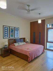 una camera da letto con un grande letto con una coperta rosa di Pristine home near New Friends colony a Nuova Delhi