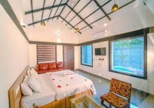 a bedroom with a bed and a chair in it at Wildside Jungle Retreat Wayanad Resort by VOYE HOMES in Wayanad