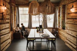 a dining room with a table and people sitting in a window at Daj Spokój in Szczyrk