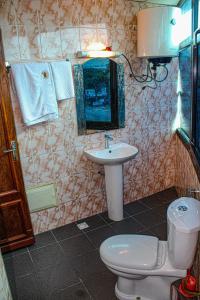 a bathroom with a toilet and a sink at Residence Blue Sky in Douala