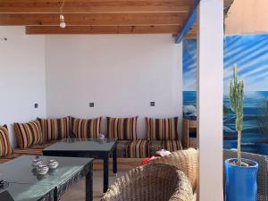 a patio with couches and a table and chairs at Hostel The Endless House Anchor point in Taghazout