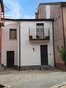 Casa blanca con balcón y 2 puertas en Casa Vacanze Dante, en San Pietro a Maida