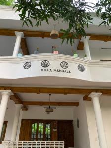 瓦卡拉的住宿－Villa Mandala Guest House，一座有标志的建筑,上面写着曼达拉别墅的标志