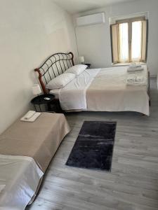 1 dormitorio con 2 camas y ventana en Casa Vacanze Dante en San Pietro a Maida