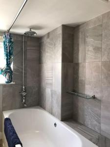 a white bath tub in a bathroom with a shower at Charming property in the heart of Midhurst in Midhurst
