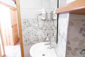 La salle de bains est pourvue d'un lavabo et d'un miroir. dans l'établissement Guesthouse Močivnik, à Okroglice