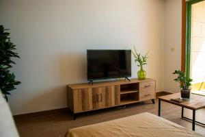 a living room with a flat screen tv on a wooden cabinet at Beachfront arrecife views in Arrecife