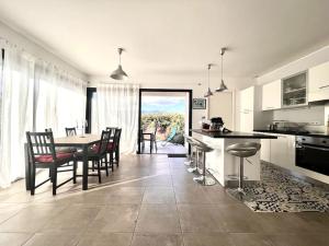 cocina y comedor con mesa y sillas en Maison Récente avec Piscine, en Venzolasca