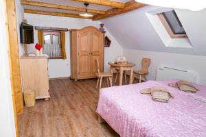 um quarto com uma cama, uma mesa e cadeiras em Guesthouse Močivnik em Okroglice