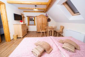 um quarto com uma cama rosa e uma mesa em Guesthouse Močivnik em Okroglice