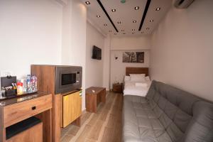 a living room with a couch and a tv at Sun and Sand Guest House in Cairo