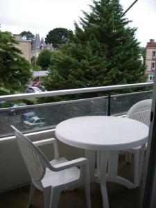 a white table and two chairs on a balcony at Résidence Le Crystal Dinard Plage in Dinard