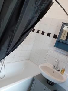 a white bathroom with a sink and a tub at Stellas Monteurwohnungen in Werdau